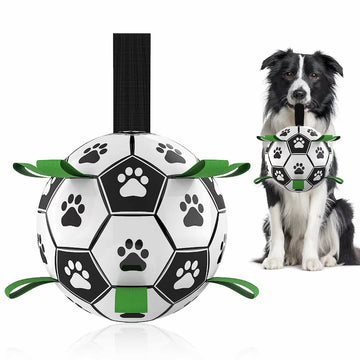 Durable dog soccer ball with nylon grab tabs being pulled by a dog, featuring a high-bounce design for outdoor water and land play.
