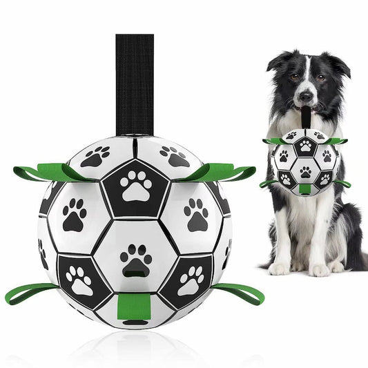 Durable dog soccer ball with nylon grab tabs being pulled by a dog, featuring a high-bounce design for outdoor water and land play.