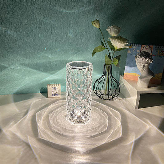 Elegant rose crystal diamond table lamp glowing with a rose-shaped shadow effect in RGB colors on a bedside table.