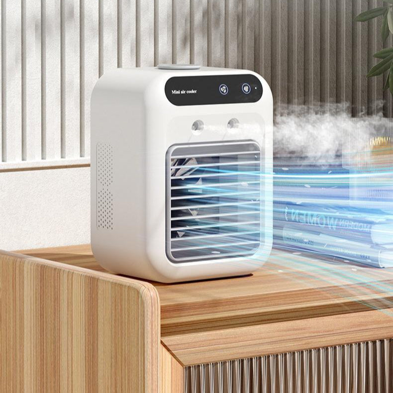 Compact white portable air cooler on a wooden desk, emitting a cool mist with blue LED lighting in a modern office setting.