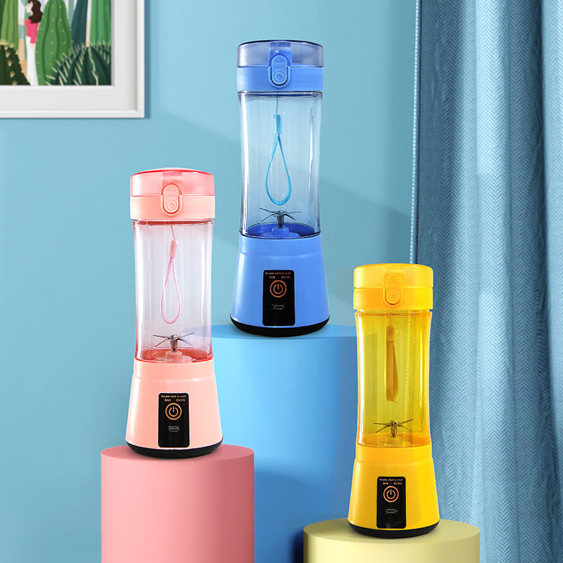 Three portable blenders in pink, blue, and yellow on colorful stands against a light blue wall.