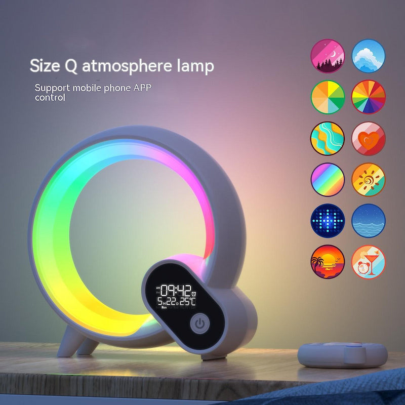 White G-shaped Smart Q sunrise alarm clock with RGB atmosphere lighting, built-in Bluetooth speaker, and wireless charging base.