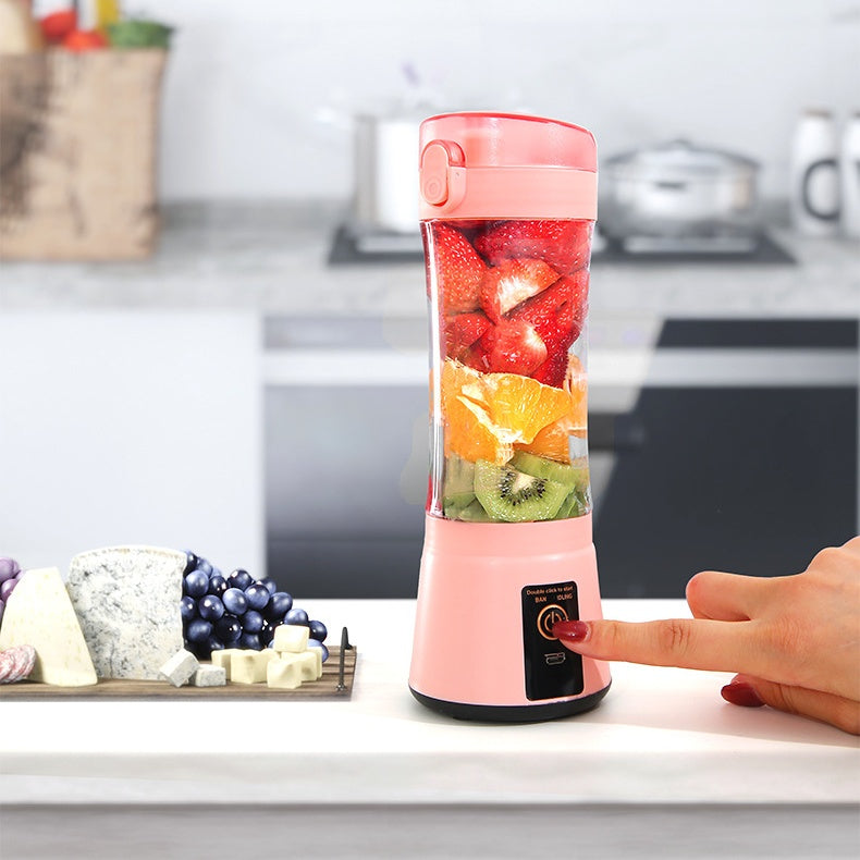 Pink portable blender with fruits inside on a kitchen counter